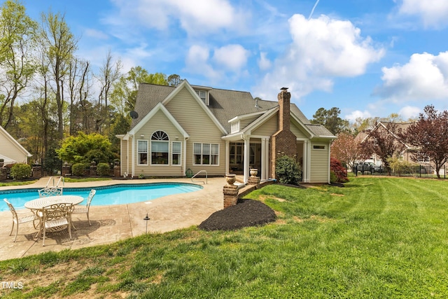 rear view of property with a patio and a lawn