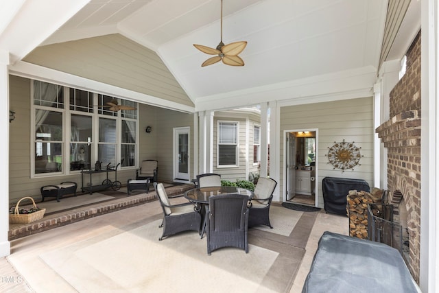 sunroom / solarium with ornate columns, ceiling fan, and lofted ceiling