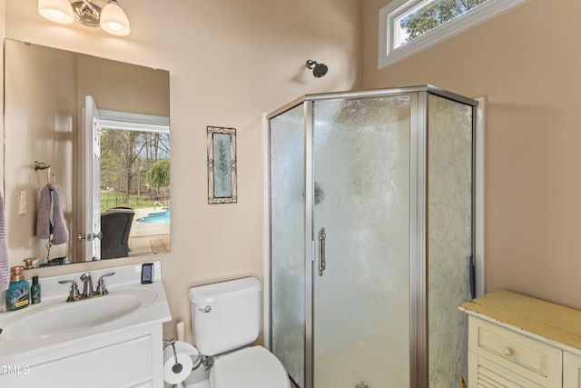 bathroom with vanity, an enclosed shower, toilet, and plenty of natural light