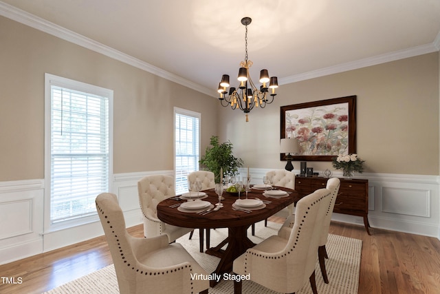 dining room featuring crown molding, hardwood / wood-style floors, and a notable chandelier