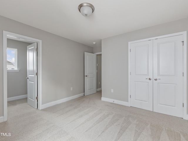 unfurnished bedroom with light carpet and a closet