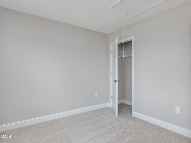 unfurnished bedroom with light colored carpet and a closet