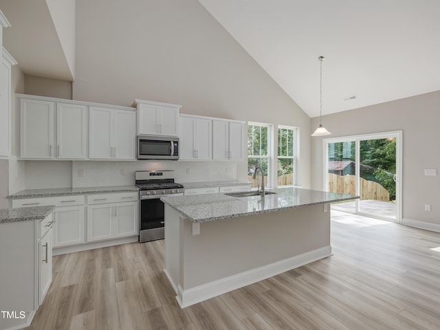 kitchen with sink, white cabinetry, stainless steel appliances, and high vaulted ceiling