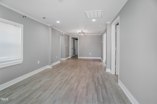 unfurnished room featuring ornamental molding and light wood-type flooring