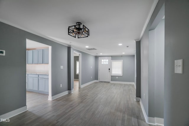 interior space with crown molding and light hardwood / wood-style flooring