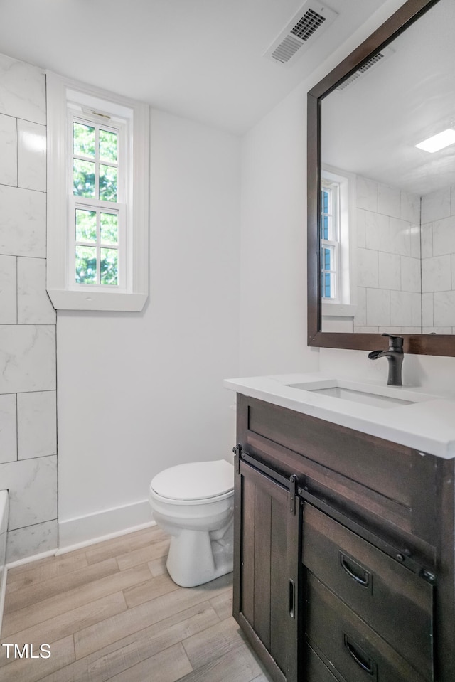 bathroom with vanity, toilet, and hardwood / wood-style floors