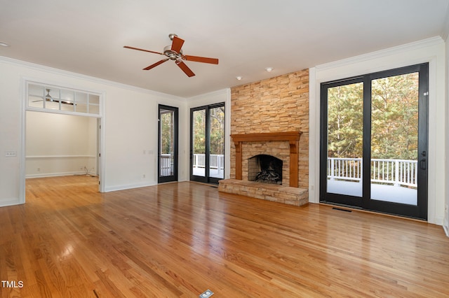 unfurnished living room featuring a fireplace, ceiling fan, plenty of natural light, and light hardwood / wood-style flooring