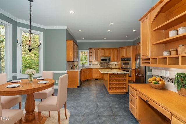 kitchen featuring a kitchen island with sink, hanging light fixtures, light stone countertops, appliances with stainless steel finishes, and tasteful backsplash