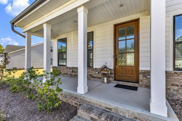 view of exterior entry with a porch