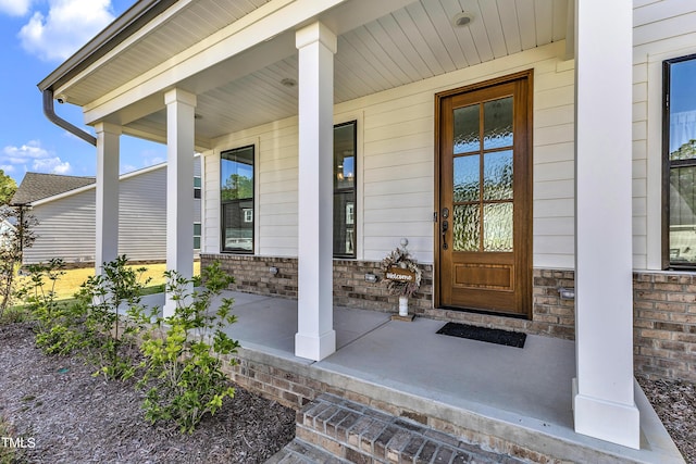 view of exterior entry featuring covered porch