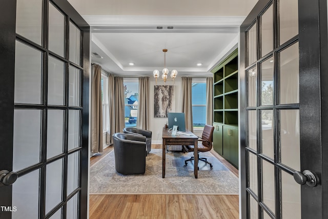 office space featuring french doors, wood-type flooring, a tray ceiling, and a notable chandelier