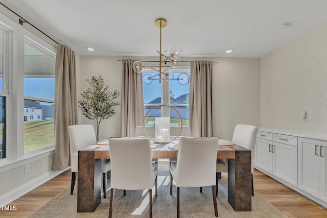 dining space featuring recessed lighting, a notable chandelier, baseboards, and light wood-type flooring