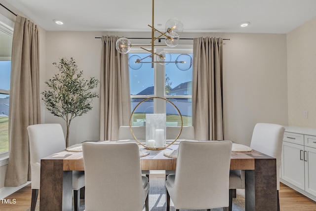 dining space featuring light hardwood / wood-style floors and an inviting chandelier