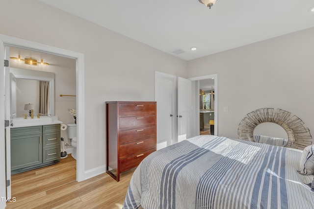 bedroom with light wood finished floors, recessed lighting, visible vents, baseboards, and ensuite bathroom