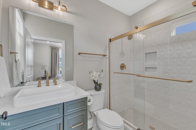 bathroom with toilet, vanity, and an enclosed shower