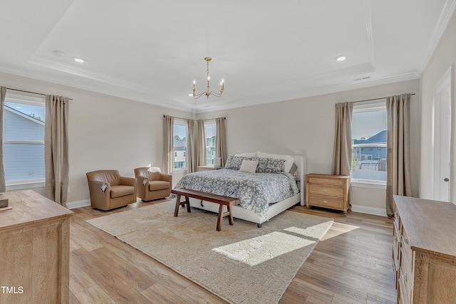 bedroom featuring a raised ceiling, an inviting chandelier, ornamental molding, and light hardwood / wood-style flooring