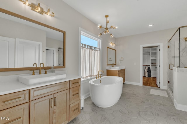 bathroom featuring tile patterned flooring, vanity, a notable chandelier, and plus walk in shower