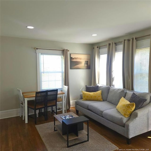 living room with a healthy amount of sunlight and dark wood-type flooring