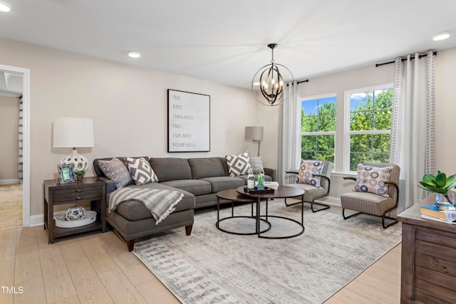 living room with light hardwood / wood-style flooring and a notable chandelier