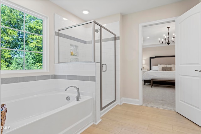 bathroom featuring a chandelier, plus walk in shower, and wood-type flooring