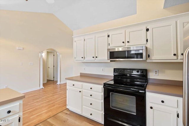 kitchen featuring light hardwood / wood-style flooring, black electric range oven, white cabinets, and vaulted ceiling