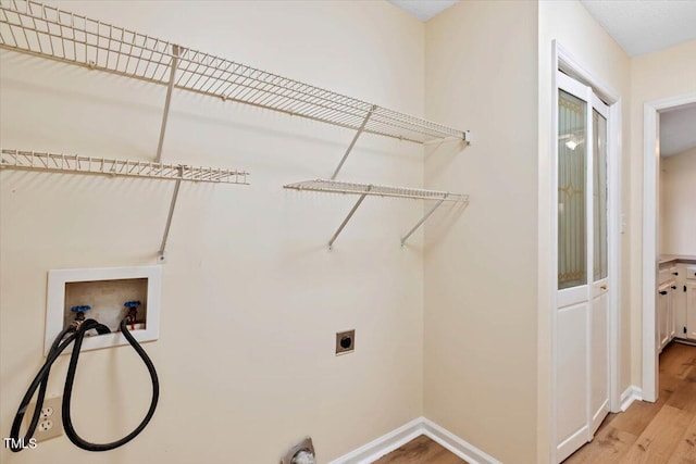 laundry room featuring hookup for an electric dryer, washer hookup, and light wood-type flooring