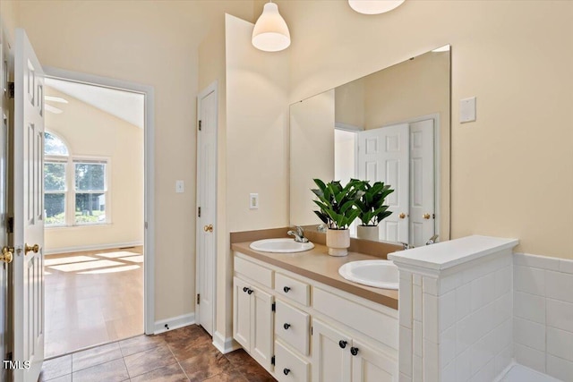 bathroom featuring vanity, vaulted ceiling, and tile patterned floors