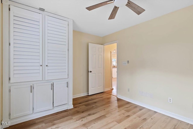 unfurnished bedroom featuring a closet, light hardwood / wood-style floors, and ceiling fan