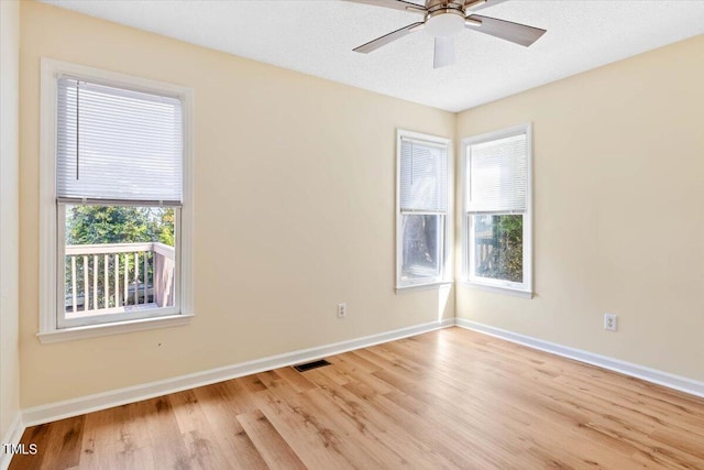 empty room with a textured ceiling, light hardwood / wood-style floors, and ceiling fan