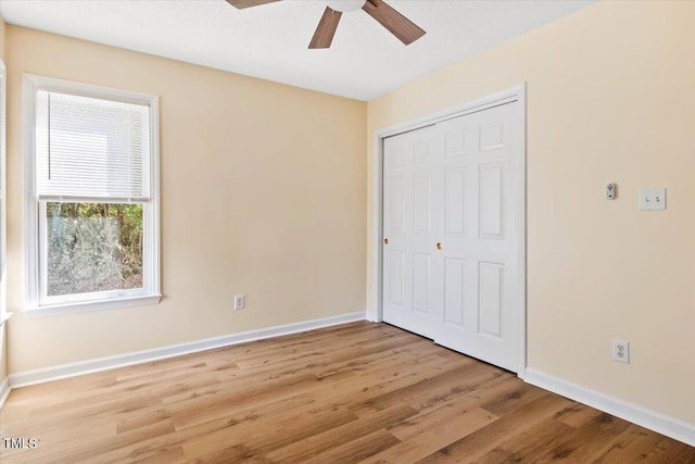 unfurnished bedroom featuring a closet, light hardwood / wood-style floors, and ceiling fan