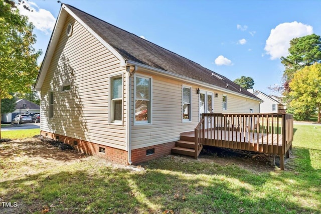 rear view of property with a deck and a lawn