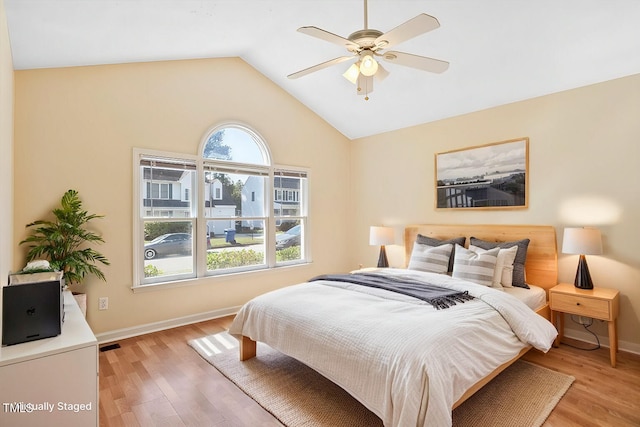 bedroom with light hardwood / wood-style flooring, vaulted ceiling, and ceiling fan