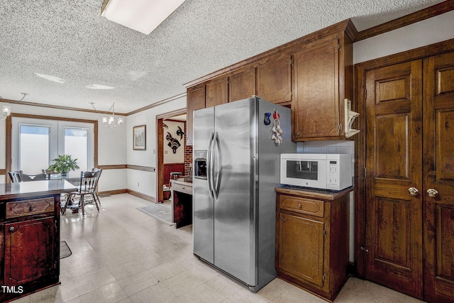 2554 Davis Mill Rd, Fremont, NC 27830 - kitchen featuring stainless steel fridge with ice dispenser, white microwave, ornamental molding, a textured ceiling, and baseboards