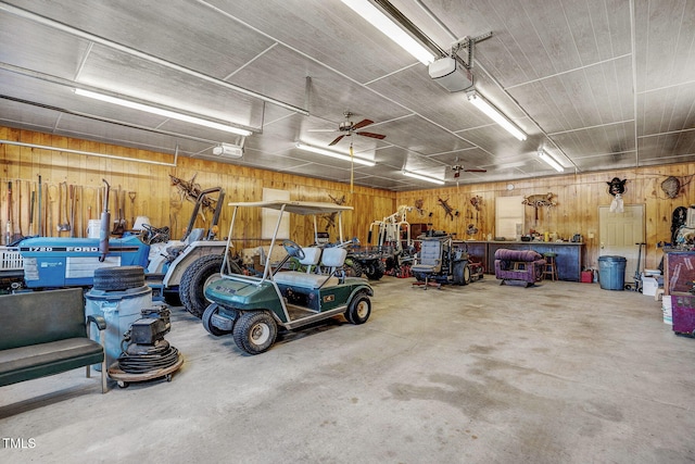 2554 Davis Mill Rd, Fremont, NC 27830 - garage featuring wooden walls, ceiling fan, a garage door opener, and a workshop area