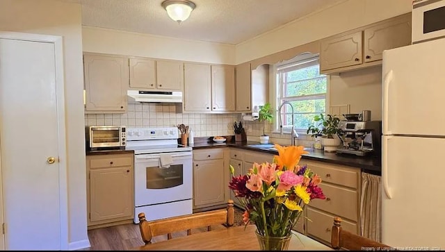 kitchen with decorative backsplash, a textured ceiling, light wood-type flooring, sink, and white appliances