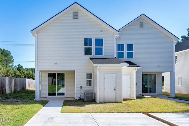 rear view of property with a yard and central AC