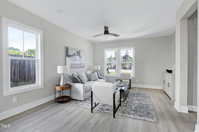 living room with light hardwood / wood-style floors and ceiling fan