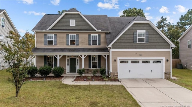 craftsman house featuring covered porch, central AC, a front lawn, and a garage