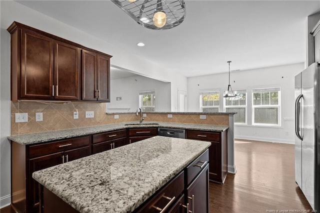 kitchen featuring a kitchen island, dark hardwood / wood-style floors, sink, pendant lighting, and appliances with stainless steel finishes