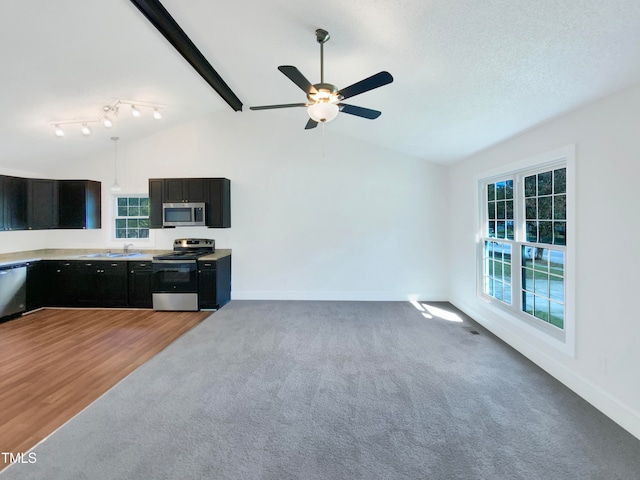 kitchen with ceiling fan, wood-type flooring, sink, lofted ceiling with beams, and stainless steel appliances