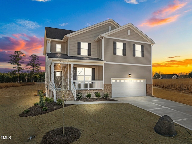 view of front of house featuring a porch, a yard, and a garage