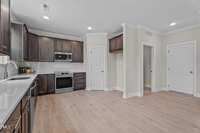 15 Diamond Creek Dr, Zebulon, NC 27597 - kitchen featuring stainless steel appliances, dark brown cabinetry, light wood-type flooring, backsplash, and ornamental molding