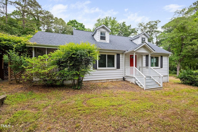 cape cod house featuring a front yard