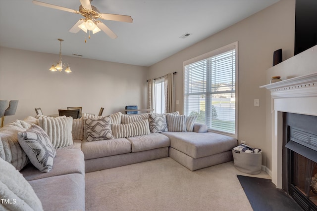 living room with carpet flooring and ceiling fan with notable chandelier