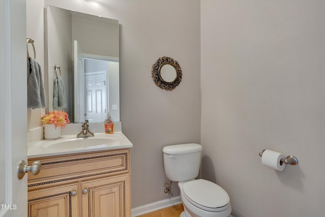 bathroom featuring vanity, hardwood / wood-style flooring, and toilet