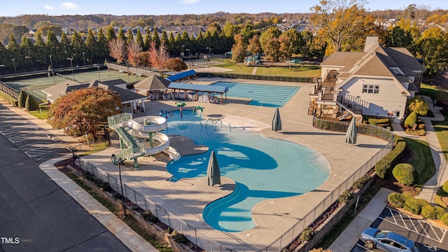 view of pool featuring tennis court and a water slide