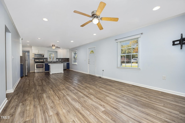 unfurnished living room with ornamental molding, hardwood / wood-style flooring, and ceiling fan