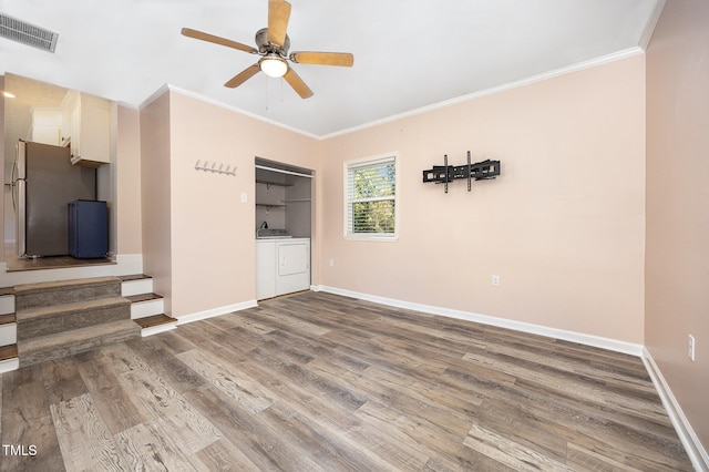 unfurnished living room with hardwood / wood-style floors, crown molding, washing machine and dryer, and ceiling fan