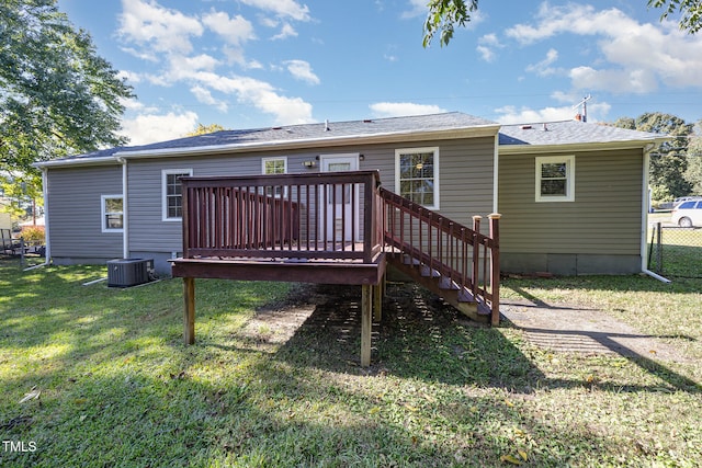 rear view of property with a wooden deck and a lawn