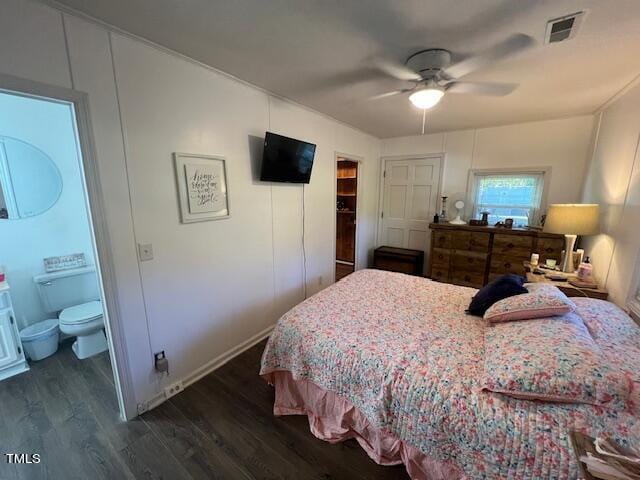 bedroom featuring ceiling fan, dark hardwood / wood-style floors, and connected bathroom